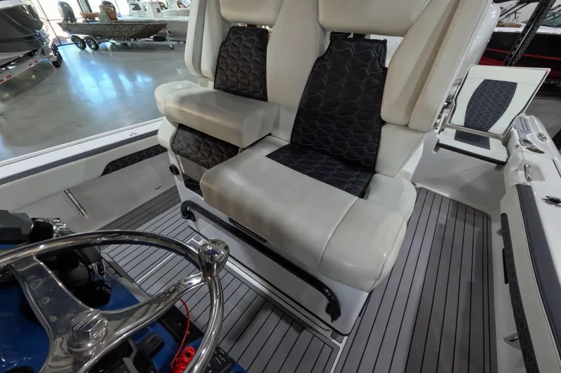Slide: The Image of 2024 Tidewater boat interior with luxurious seating and sleek steering wheel design. - 12