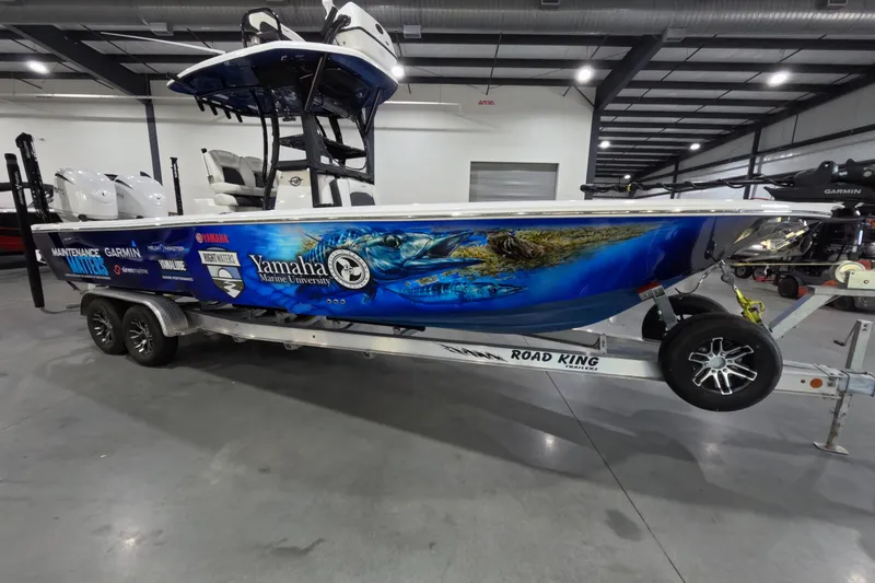 Slide: The Image of 2024 Tidewater boat on trailer with vibrant marine graphics and sponsor logos in a showroom. - 3