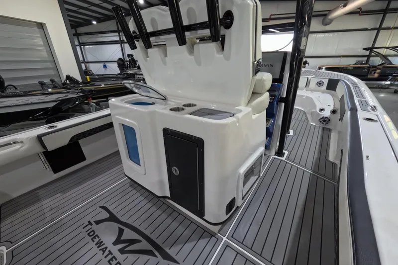 Slide: The Image of 2024 Tidewater boat interior with sleek seating, rod holders, and modern design in a showroom. - 9