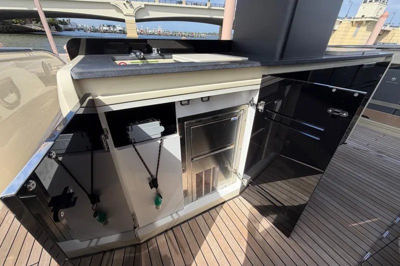 Slide: The Image of 2024 Invictus TT460 yacht deck with open storage compartments and sleek design. - 15