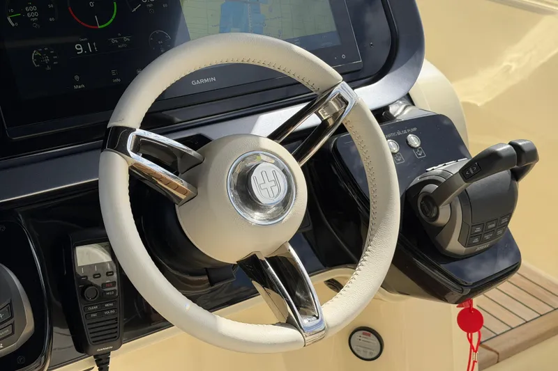 Slide: The Image of Steering wheel and controls of 2024 Invictus TT460 yacht, featuring Garmin navigation system. - 22