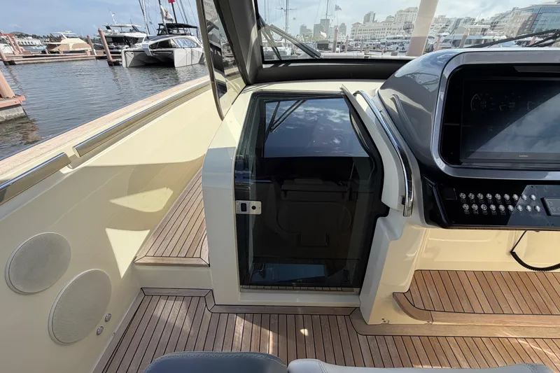 Slide: The Image of 2024 Invictus TT460 yacht cockpit with modern controls and marina view. - 25