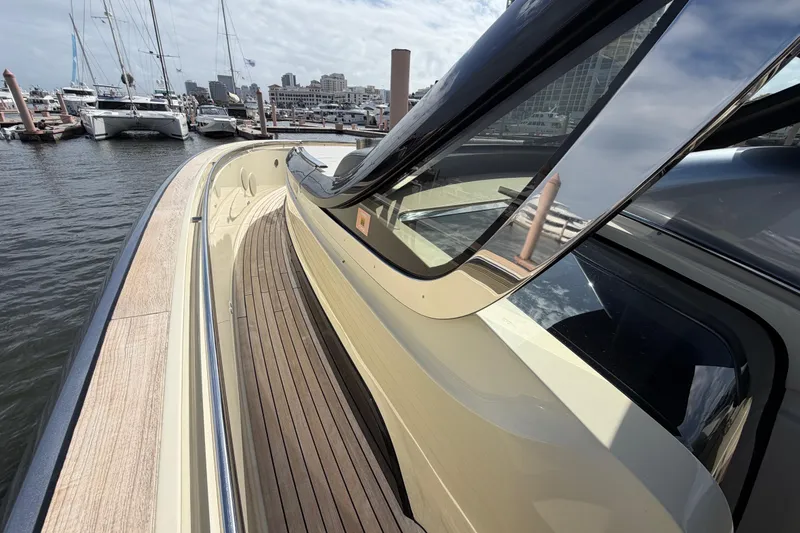 Slide: The Image of 2024 Invictus TT460 yacht docked, showcasing sleek design and wooden deck. - 31