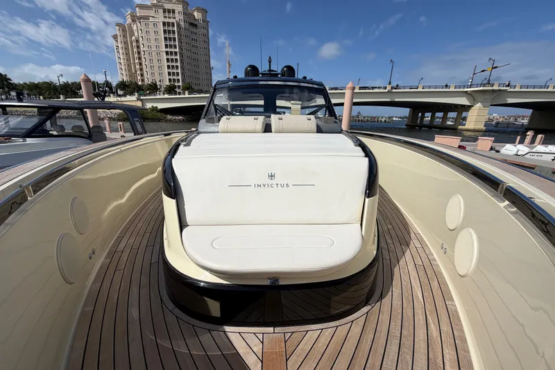 Slide: The Image of 2024 Invictus TT460 yacht with sleek design, docked near a bridge and luxury building. - 34