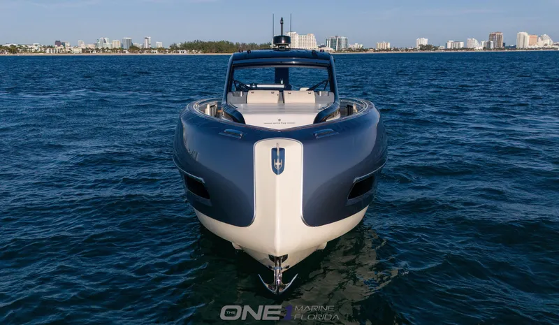 Slide: The Image of 2024 Invictus TT460 luxury yacht on open water with city skyline in background. - 4