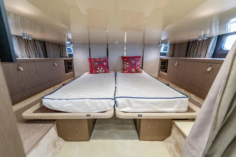 Slide: The Image of Luxurious 2024 Invictus TT460 yacht cabin with twin beds and vibrant pillows. - 78