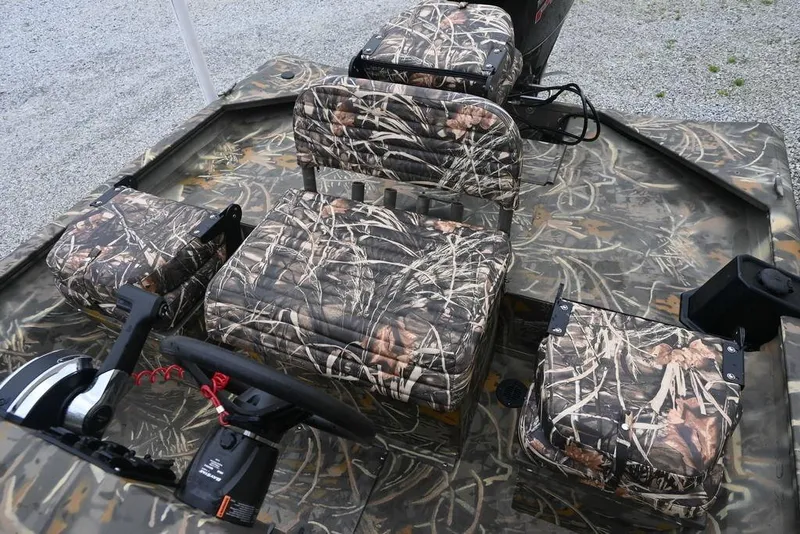 Slide: The Image of 2023 War Eagle 961 Blackhawk boat interior with camouflage seating and steering console. - 4