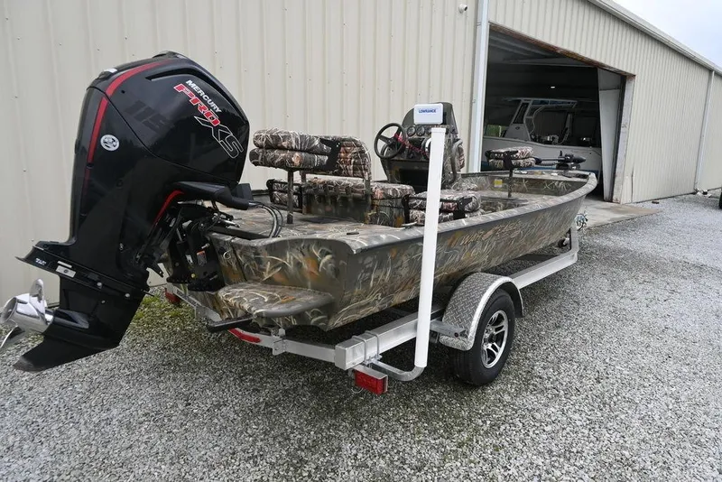 Slide: The Image of 2023 War Eagle 961 Blackhawk boat with camo seats and Mercury engine on trailer. - 5