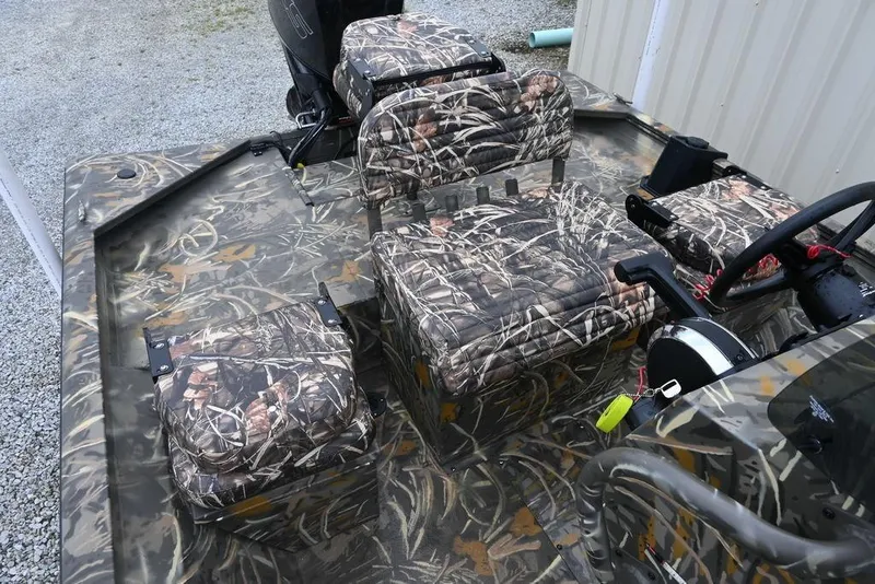 Slide: The Image of 2023 War Eagle 961 Blackhawk boat interior with camouflage seating and steering console. - 6