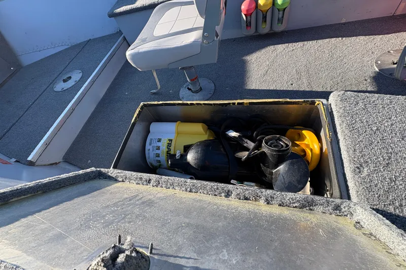 Slide: The Image of Storage compartment in a 1995 Lund 1440-V Rebel Tiller boat with equipment inside. - 12
