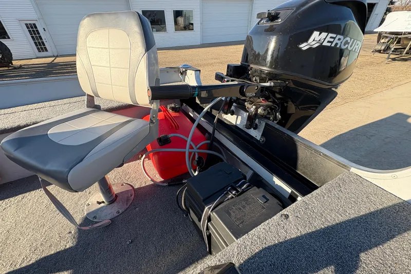 Slide: The Image of 1995 Lund 1440-V Rebel Tiller boat interior with Mercury outboard motor and seating. - 13