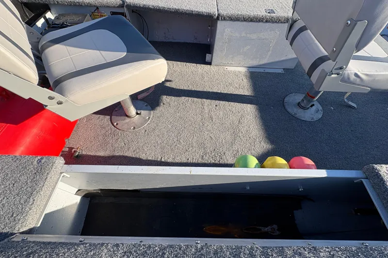 Slide: The Image of 1995 Lund 1440-V Rebel Tiller boat interior with seats and storage compartment. - 15