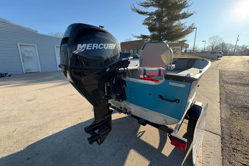Slide: The Image of 1995 Lund 1440-V Rebel Tiller boat with Mercury outboard motor on trailer. - 16