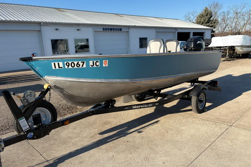 Slide: The Image of 1995 Lund 1440-V Rebel Tiller boat on trailer outside showroom. - 6