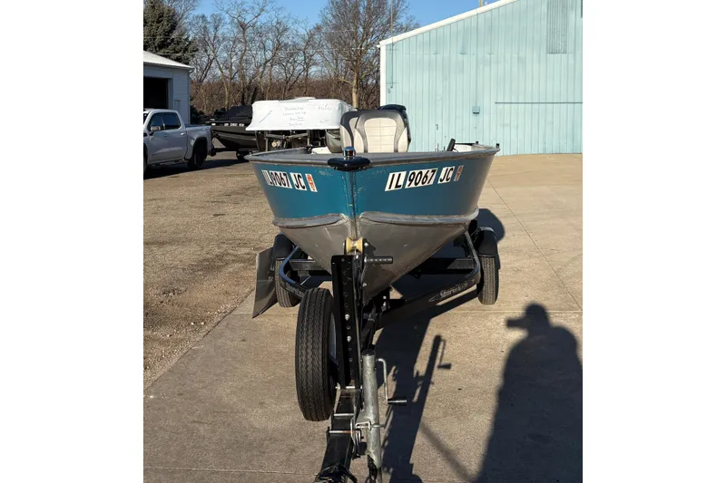 Slide: The Image of 1995 Lund 1440-V Rebel Tiller boat on trailer, parked outdoors. - 7