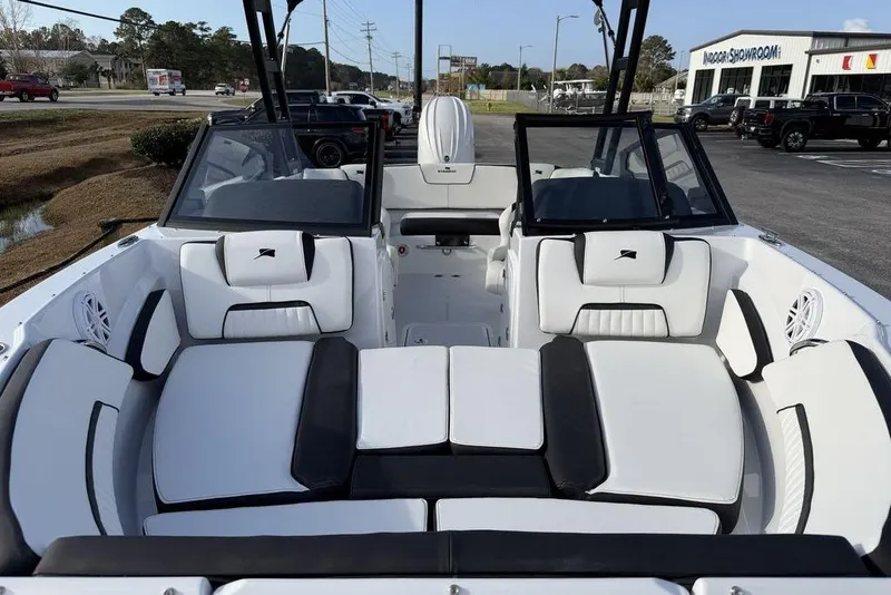 Slide: The Image of 2026 Stingray 20 SBX boat interior with sleek white and black seating, parked outdoors. - 10