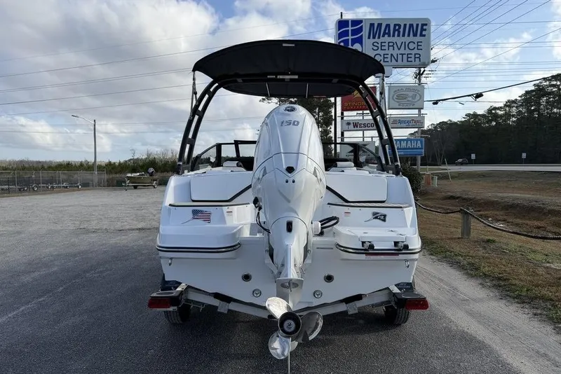 Slide: The Image of 2026 Stingray 20 SBX boat at marine service center, rear view with outboard motor. - 12