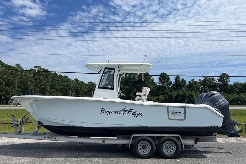 The Image of 2026 Sea Hunt Gamefish 25 boat on trailer, side view, with Yamaha engines. - 1