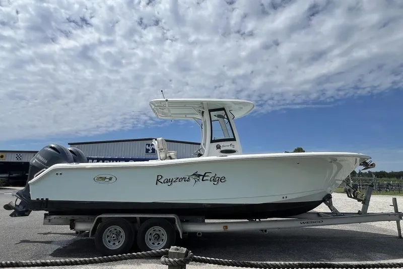 Slide: The Image of 2026 Sea Hunt Gamefish 25 boat on trailer under cloudy sky. - 5