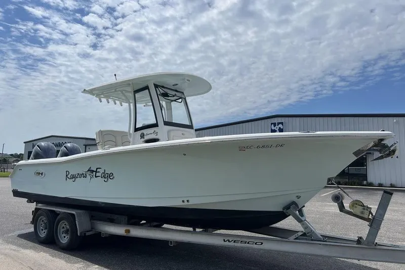 Slide: The Image of 2026 Sea Hunt Gamefish 25 boat on trailer under cloudy sky. - 7