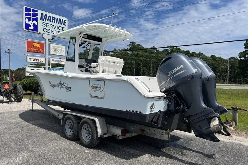 Slide: The Image of 2026 Sea Hunt Gamefish 25 boat on trailer at marine service center with Yamaha engines. - 8