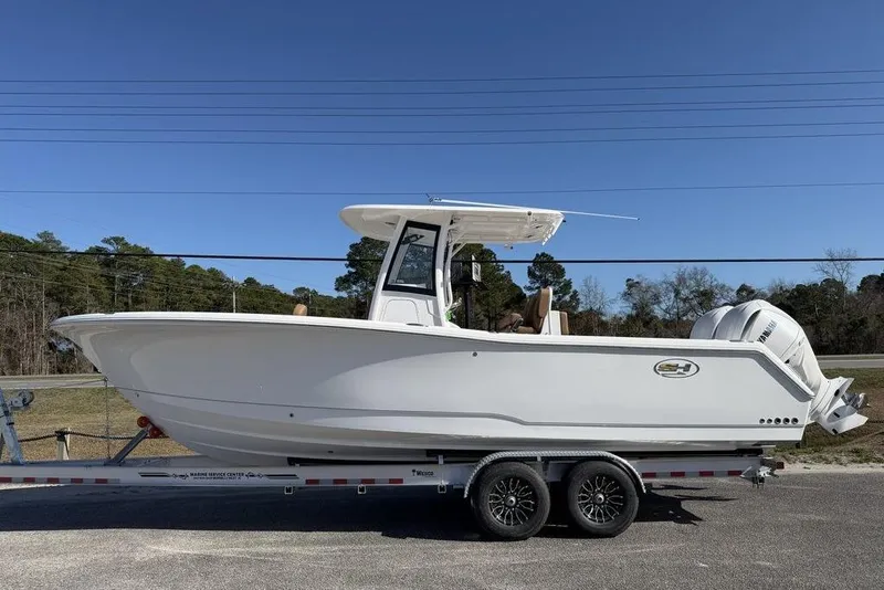 The Image of 2026 Sea Hunt Gamefish 27 boat on trailer, side view, clear sky background. - 0