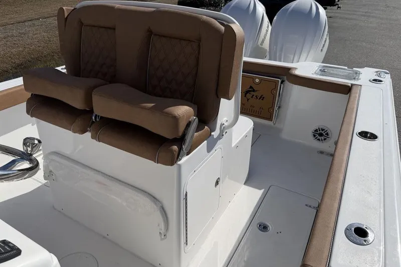 Slide: The Image of 2026 Sea Hunt Gamefish 27 boat interior with cushioned seating and dual engines. - 10