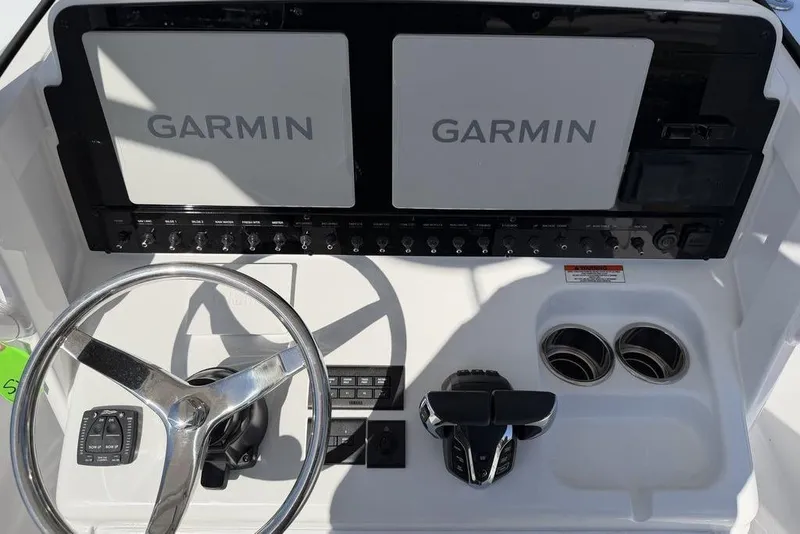 Slide: The Image of 2026 Sea Hunt Gamefish 27 dashboard with dual Garmin displays and steering wheel. - 12