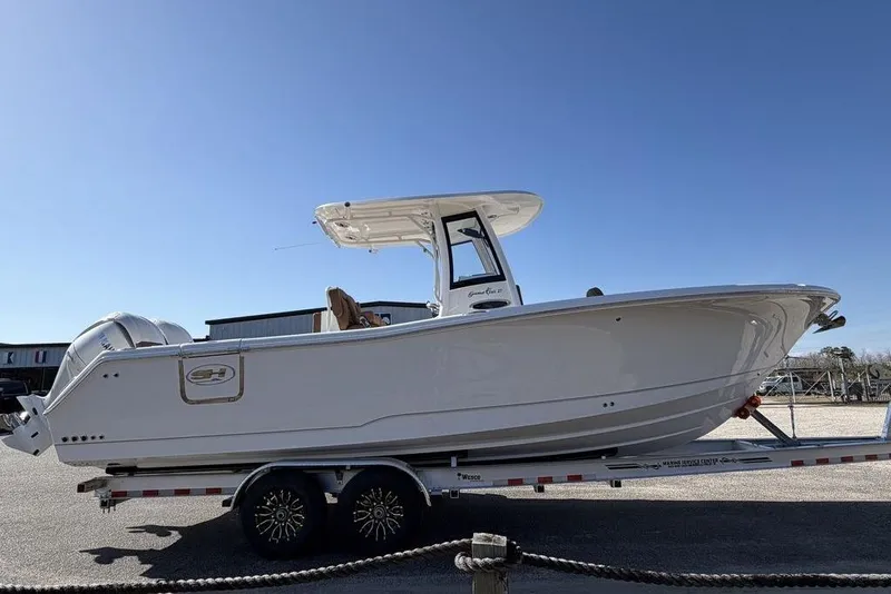 Slide: The Image of 2026 Sea Hunt Gamefish 27 boat on trailer under clear blue sky. - 2