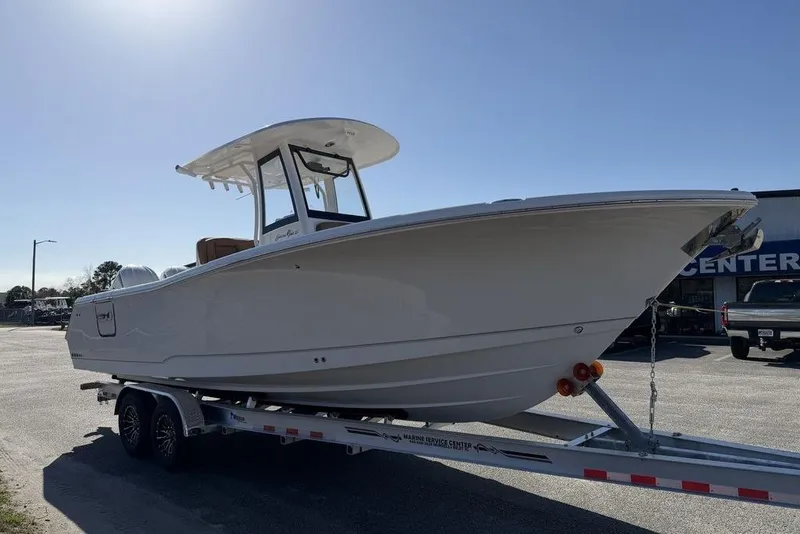 Slide: The Image of 2026 Sea Hunt Gamefish 27 boat on trailer under clear sky. - 4