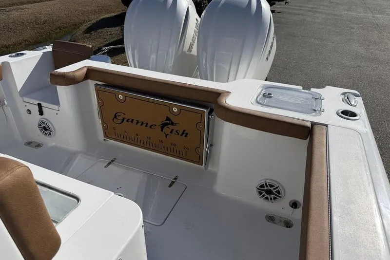 Slide: The Image of 2026 Sea Hunt Gamefish 27 boat interior with fishing rod holders and dual engines. - 6
