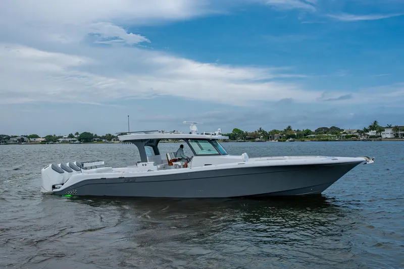Slide: The Image of 2025 HCB 48 Campeon boat on calm water under a partly cloudy sky. - 2