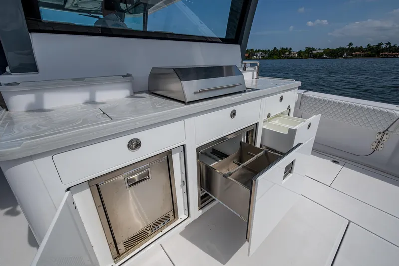 Slide: The Image of Outdoor kitchen on 2025 HCB 48 Campeon boat with stainless steel appliances and storage drawers. - 35