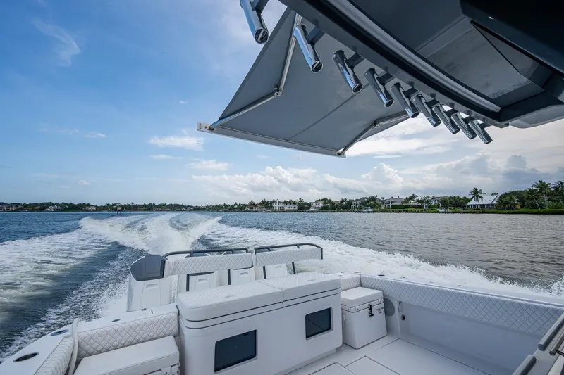 Slide: The Image of 2025 HCB 48 Campeon boat cruising on a scenic waterway under a clear blue sky. - 36