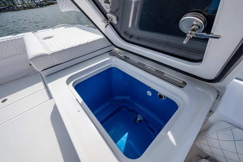 Slide: The Image of Open storage compartment on 2025 HCB 48 Campeon boat, featuring blue interior. - 46