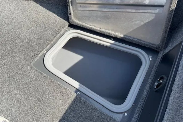 Slide: The Image of 2018 Tracker Pro Guide V-175 SC storage compartment with open lid, carpeted interior. - 15