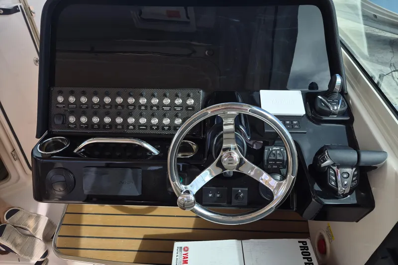 Slide: The Image of 2026 Grady-White Freedom 345 helm with steering wheel and control panel. - 11