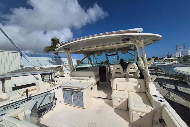 Slide: The Image of 2026 Grady-White Freedom 345 boat with spacious seating and modern design under clear blue sky. - 19