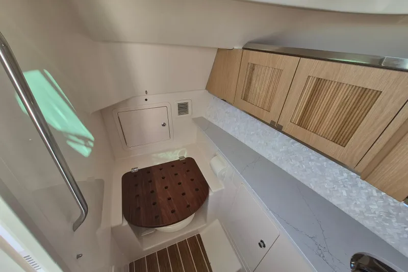 Slide: The Image of 2026 Grady-White Freedom 345 boat interior with wooden cabinetry and modern fixtures. - 21