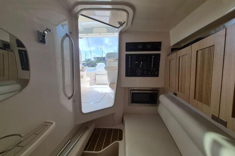 Slide: The Image of Interior of 2026 Grady-White Freedom 345 boat, featuring control panel and wooden cabinetry. - 22