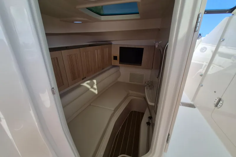 Slide: The Image of 2026 Grady-White Freedom 345 cabin interior with seating, wood cabinets, and skylight. - 23
