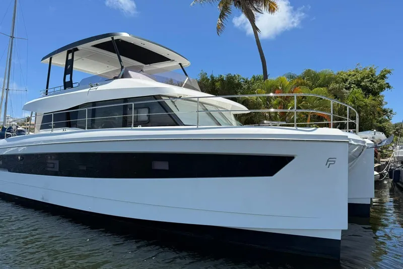 The Image of 2024 Fountaine Pajot Motor Yacht 44 docked by lush greenery under clear blue skies. - 0