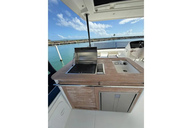 Slide: The Image of 2024 Fountaine Pajot Motor Yacht 44 docked by lush greenery under a clear blue sky. - 6