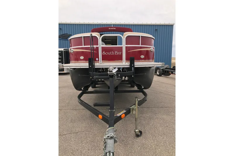 Slide: The Image of 2008 South Bay 822CR TT pontoon boat on trailer, red exterior, parked outdoors. - 2