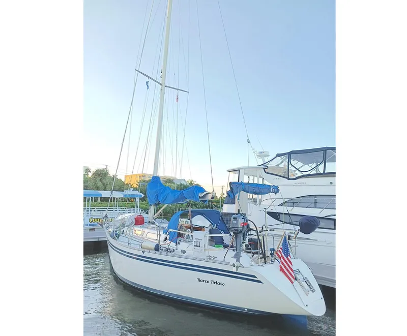 Slide: The Image of 1989 Granada 375 Atlantica sailboat docked with blue covers and American flag. - 2
