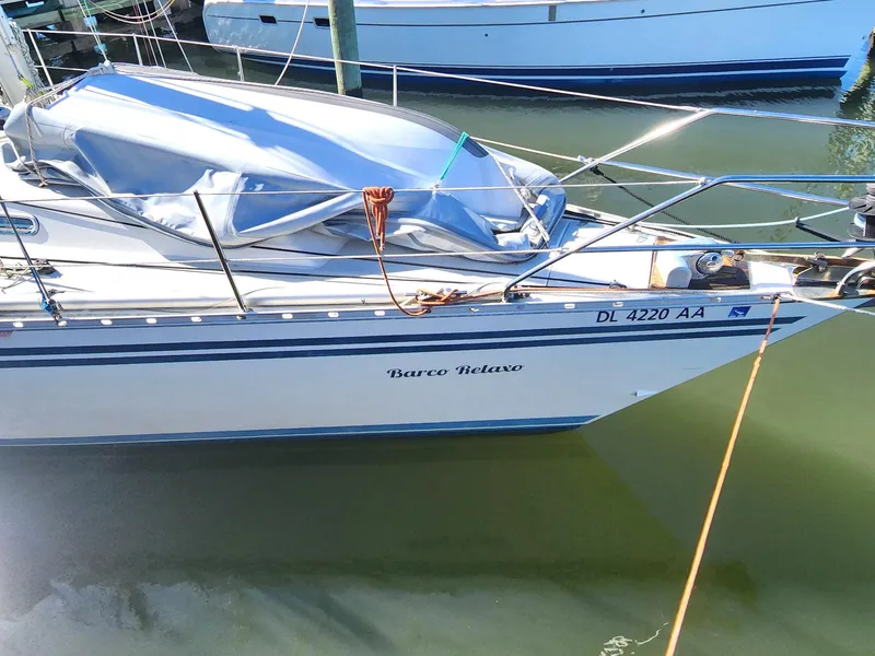 Slide: The Image of 1989 Granada 375 Atlantica sailboat docked, named "Barco Relaxo," with blue cover. - 4