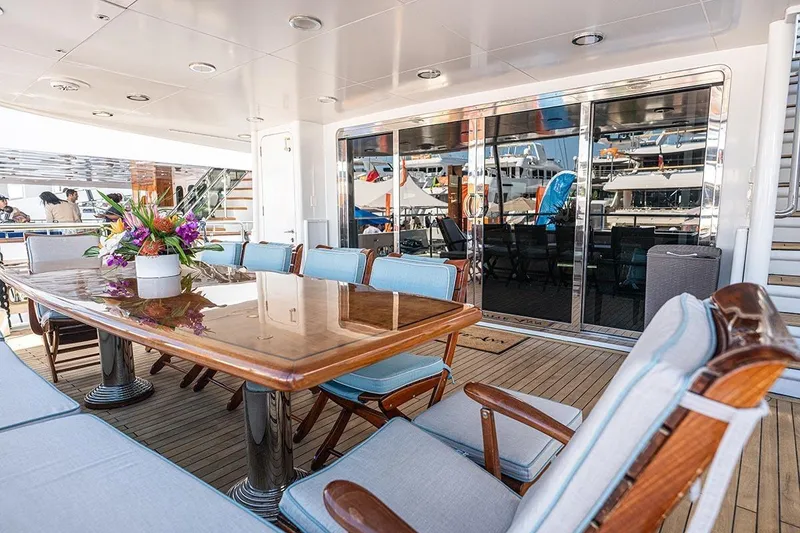 Slide: The Image of Luxurious 2003 Cheoy Lee Trideck yacht deck with elegant dining area and floral centerpiece. - 2