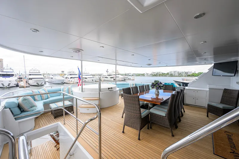 Slide: The Image of Luxurious 2003 Cheoy Lee Trideck yacht deck with dining area and seating, docked at marina. - 53