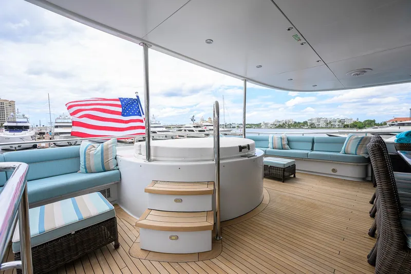 Slide: The Image of Luxurious 2003 Cheoy Lee Trideck yacht deck with seating, hot tub, and American flag. - 55