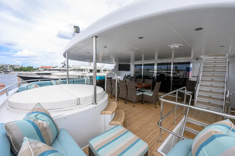 Slide: The Image of Luxurious 2003 Cheoy Lee Trideck yacht deck with seating, dining area, and scenic marina view. - 56